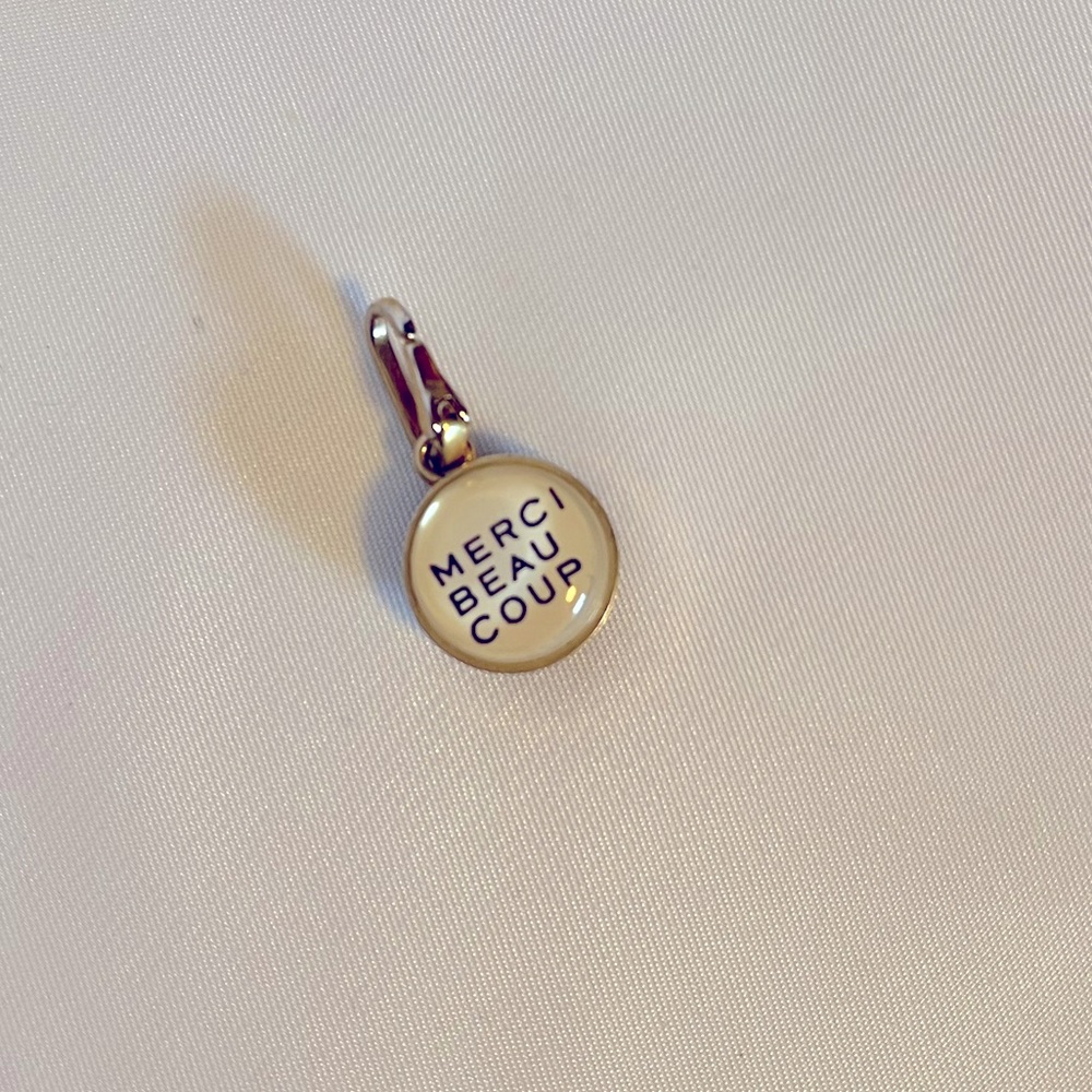 Clare V “M” Charm on one side and Merci Beaucoup on the reverse